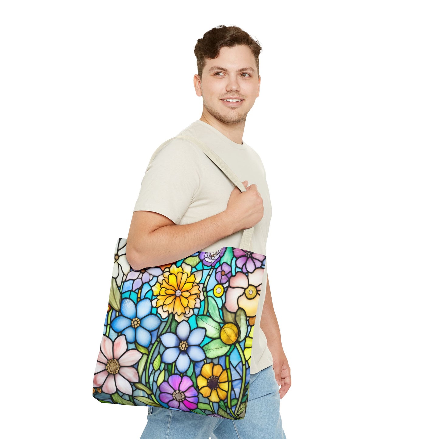 A person holding the Stained Glass Folk Art Flowers Tote Bag, which showcases a vibrant floral design made from durable polyester materials, available in three different sizes.