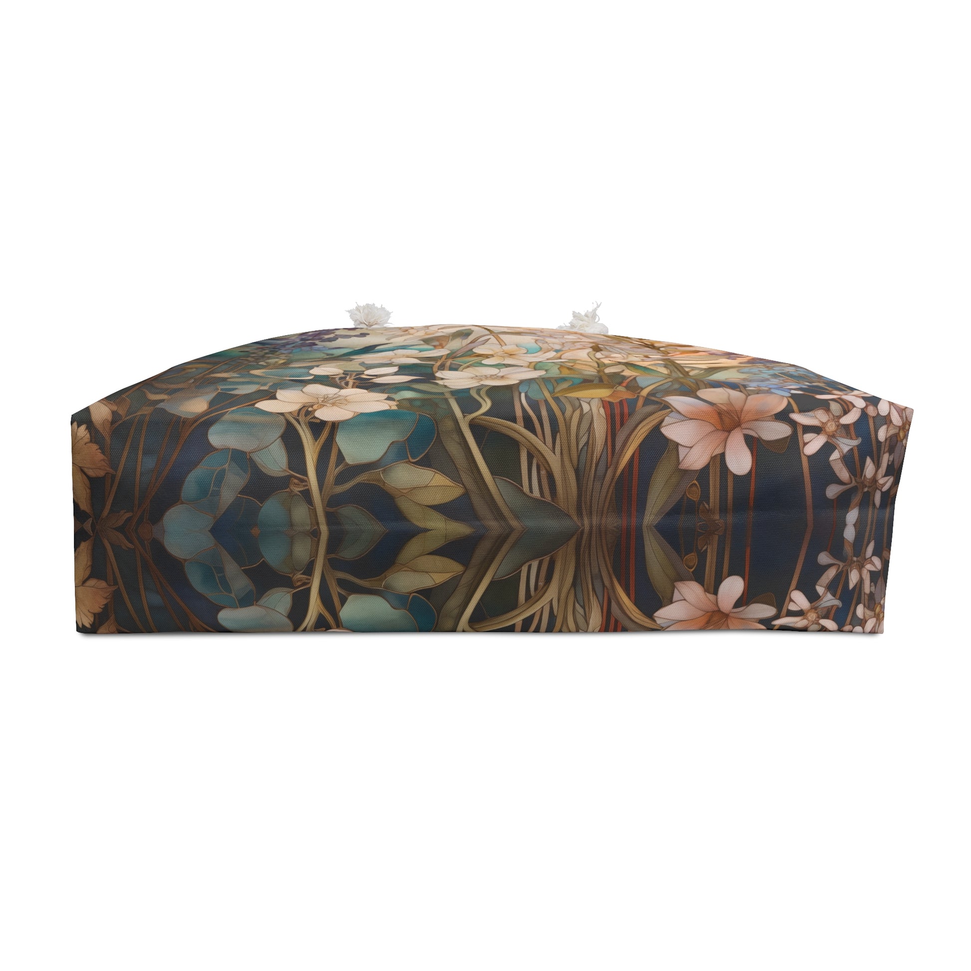 A rectangular decorative piece featuring a floral, stained-glass pattern in green, blue, and brown with mirrored leaves and stems; topped with two small tassels.