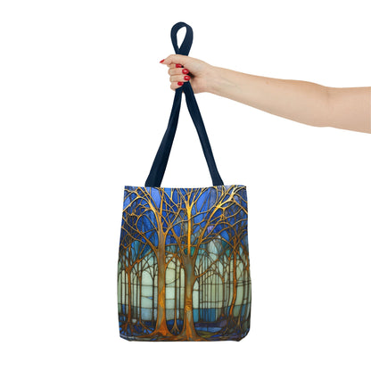 A person with red nail polish holds the Stained Glass Forest Tote Bag, Blue by its dark handles, featuring an original artist design of stylized trees with bare branches against a blue and light-colored background.