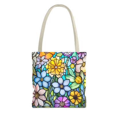 The "Stained Glass Folk Art Flowers Tote Bag" showcases an original artist design featuring a colorful stained-glass style floral pattern with various flowers in shades of blue, yellow, purple, and pink. Crafted from durable polyester materials for long-lasting use, this tote bag is available in three different sizes.