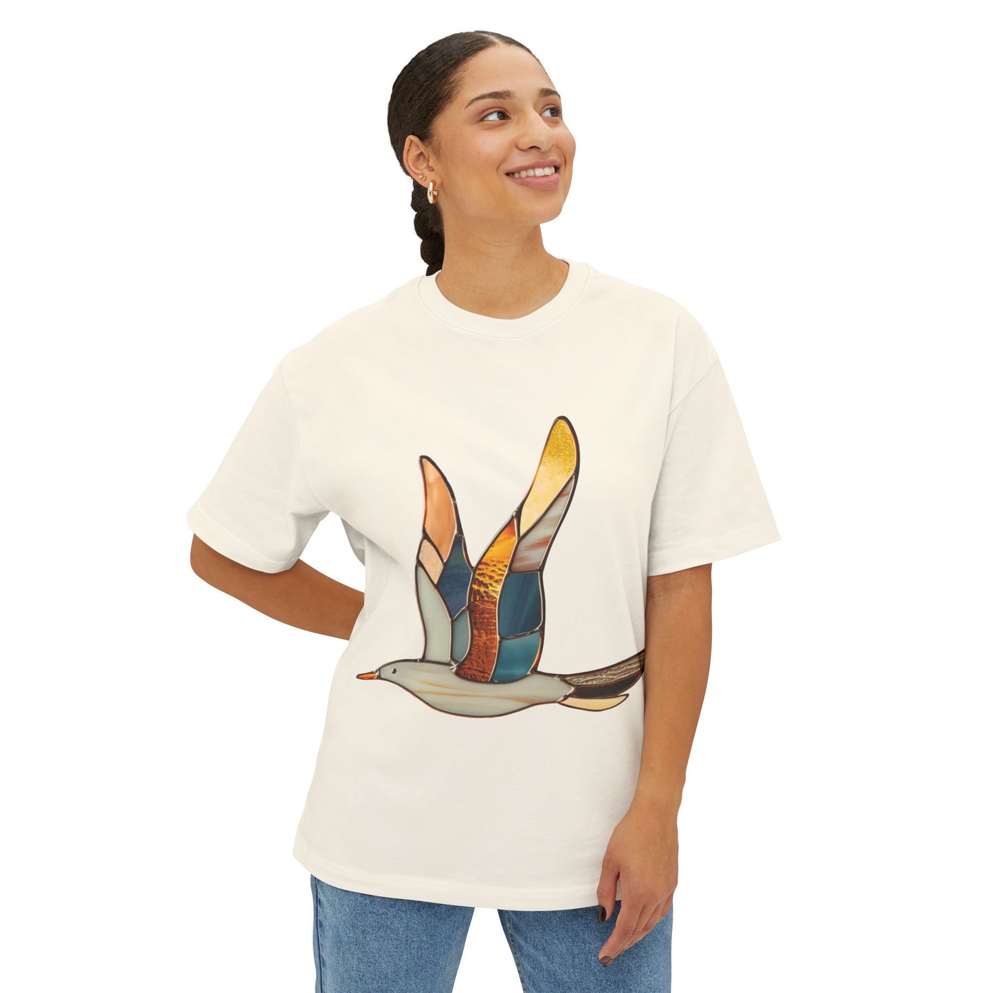 A person wearing a Stained Glass Seagull Oversized Tee Shirt stands with one hand on their hip, smiling and looking to the side.