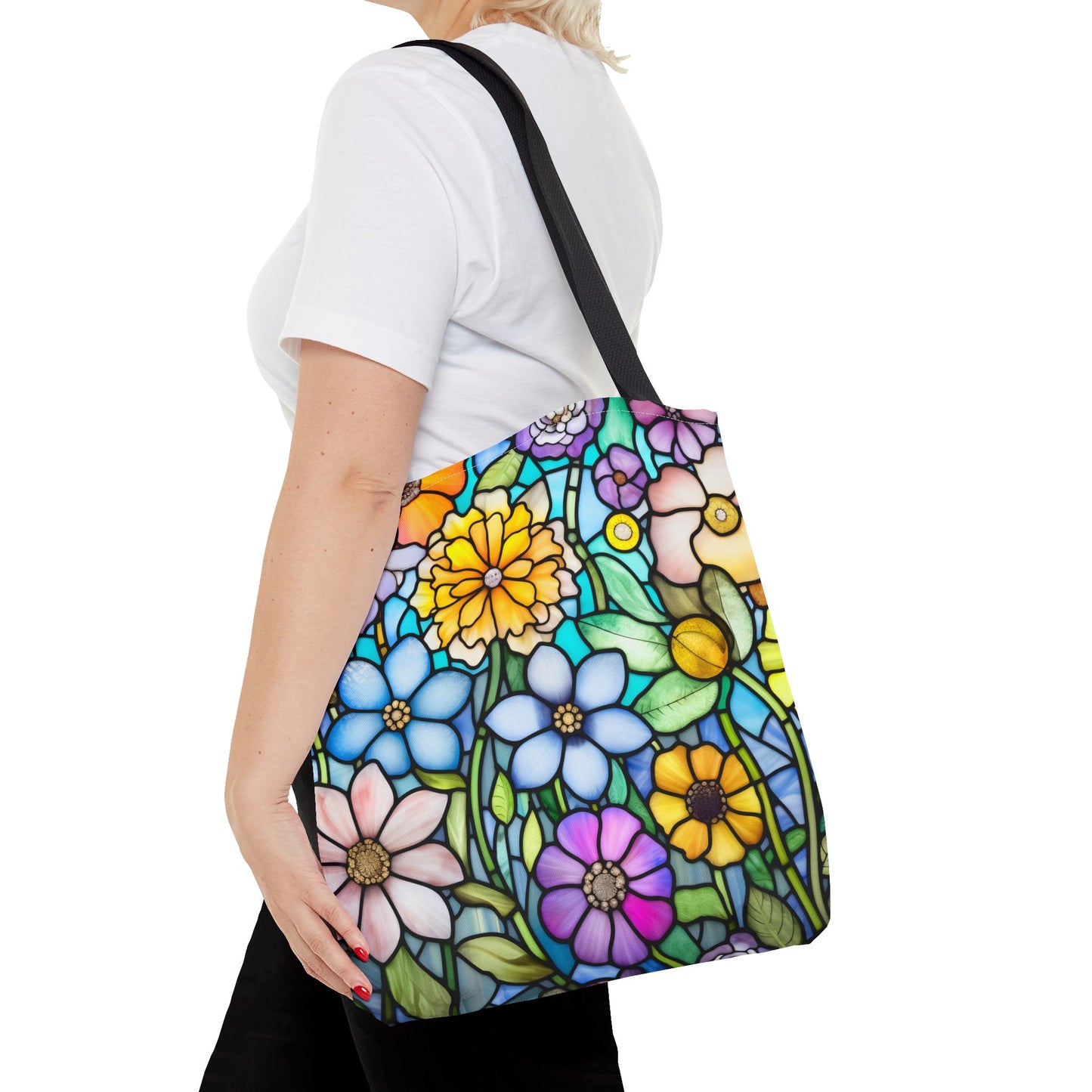 A person in a white shirt holds the Stained Glass Folk Art Flowers Tote Bag, crafted from durable polyester with an original vibrant floral pattern by the artist.