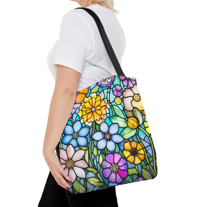 A person in a white shirt holds the Stained Glass Folk Art Flowers Tote Bag, crafted from durable polyester with an original vibrant floral pattern by the artist.