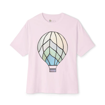 A light pink Stained Glass Hot Air Balloon Oversized Tee Shirt from Bella+Canvas, featuring a geometric hot air balloon graphic in shades of white, blue, and green.