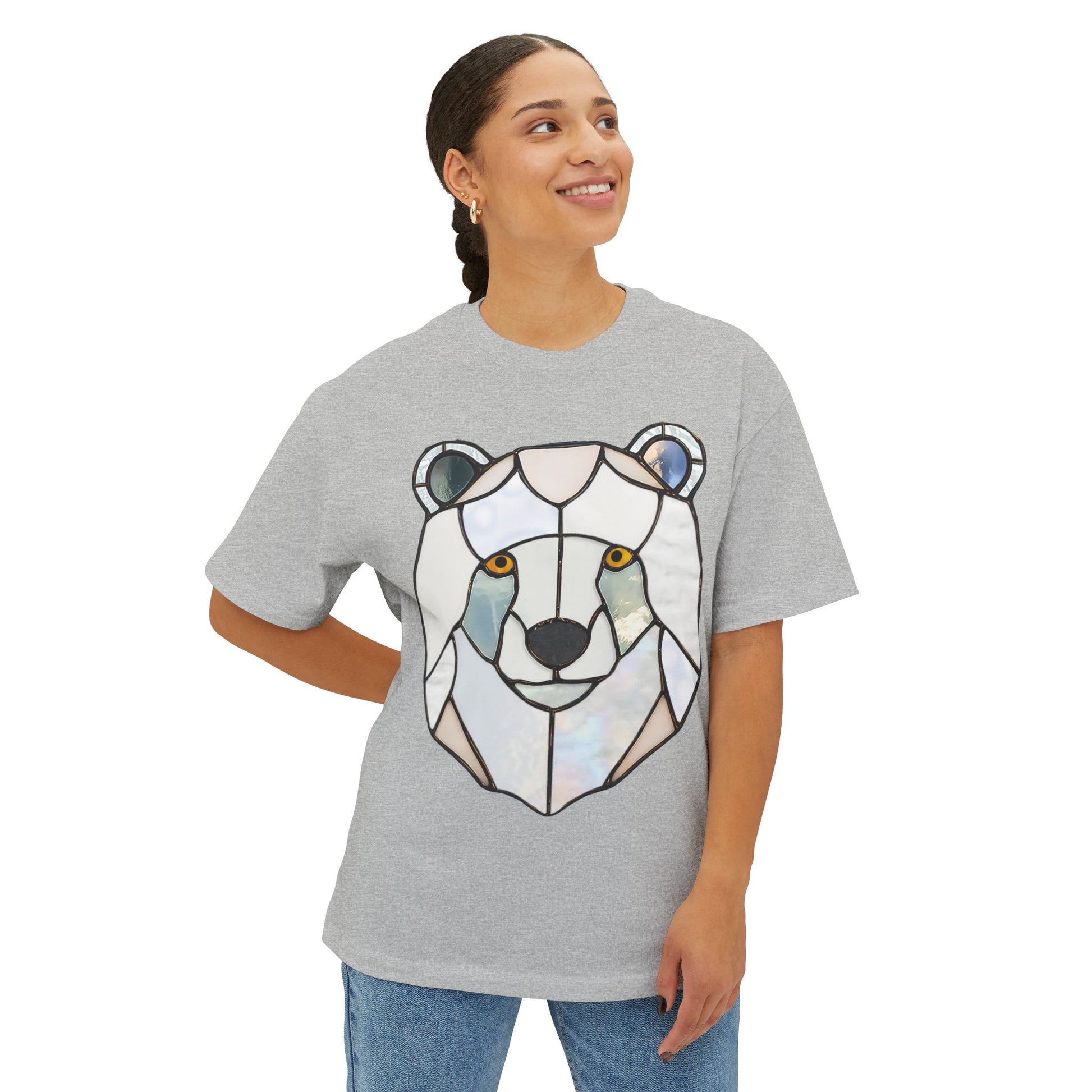 A person wearing a grey Stained Glass Polar Bear Oversized Tee Shirt with a geometric bear design stands with one hand on their hip, looking slightly to the side and smiling.