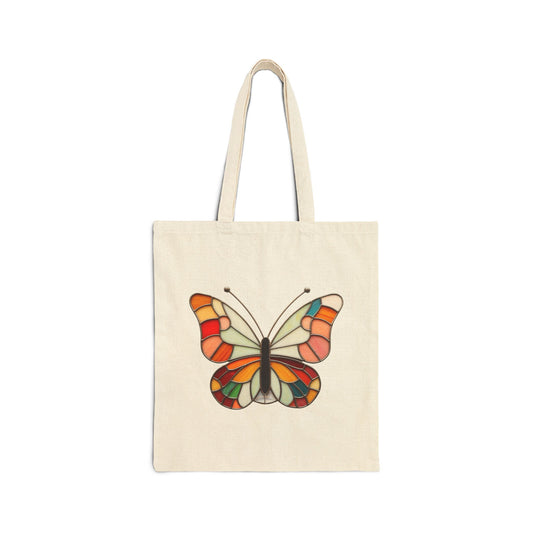  The Stained Glass Groovy Butterfly Cotton Canvas Tote Bag is a beige cotton canvas bag adorned with a vibrant butterfly design that evokes the beauty of stained glass art on the front.