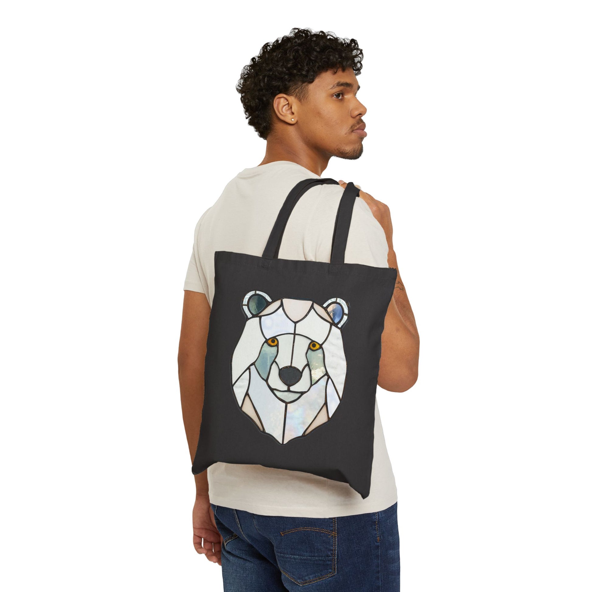 A man in a white t-shirt and blue jeans carries a Stained Glass Polar Bear Cotton Canvas Tote Bag.