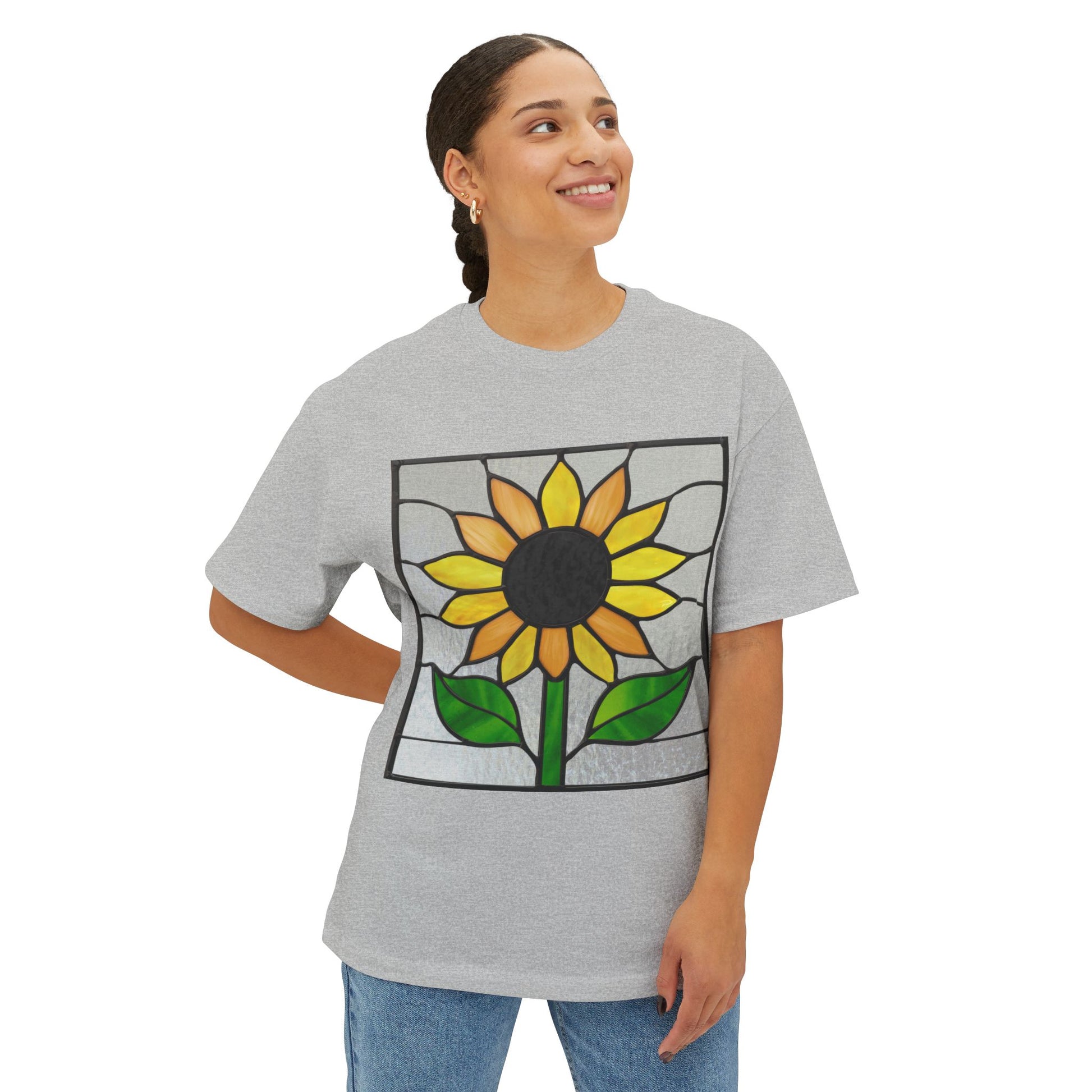 Person wearing a light gray Stained Glass Sunflower Oversized Tee Shirt by Bella+Canvas, standing and smiling with their left hand on their hip.