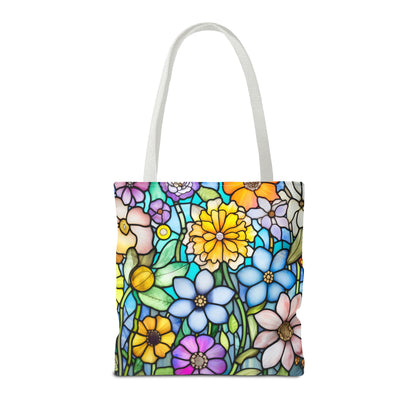 The Stained Glass Folk Art Flowers Tote Bag, available in three sizes, boasts durable polyester construction and white handles. It features a vibrant floral design with colorful blossoms and green leaves on a white background.