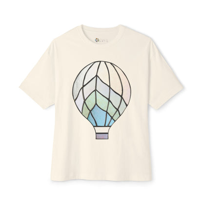 The Stained Glass Hot Air Balloon Oversized Tee Shirt by Bella+Canvas features a beautiful white fabric adorned with a pastel-styled hot air balloon design reminiscent of stained glass, making it an ideal choice for an oversized tee.