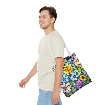 A person walks, smiling, in a light beige t-shirt and blue jeans, carrying a Stained Glass Folk Art Flowers Tote Bag featuring an original artist design over their shoulder. The background is plain white.