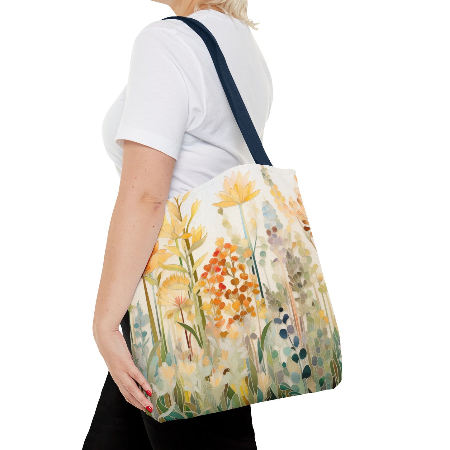 A person wearing a white t-shirt carries a Stained Glass Fall Flowers Tote Bag, displaying an original design of colorful floral patterns with yellow and orange flowers, elegantly slung over their shoulder.