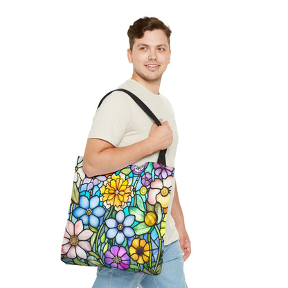 A person with short brown hair carries the Stained Glass Folk Art Flowers Tote Bag, featuring a vibrant and original artist design inspired by stained glass. They wear a light beige shirt and light blue jeans.