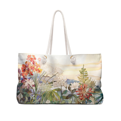 The Stained Glass Wildflowers Oversized Tote Bag features a stained glass wildflower design with flowers in red, pink, orange, white, and green on a sunny sky background. It has sturdy white rope handles.