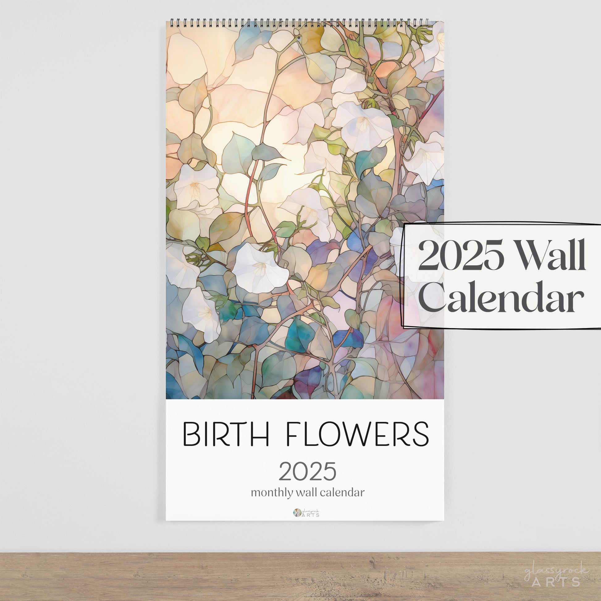 The birth flowers calendar, a 2025 monthly wall calendar with floral-themed original artwork, on a wood table surface. 