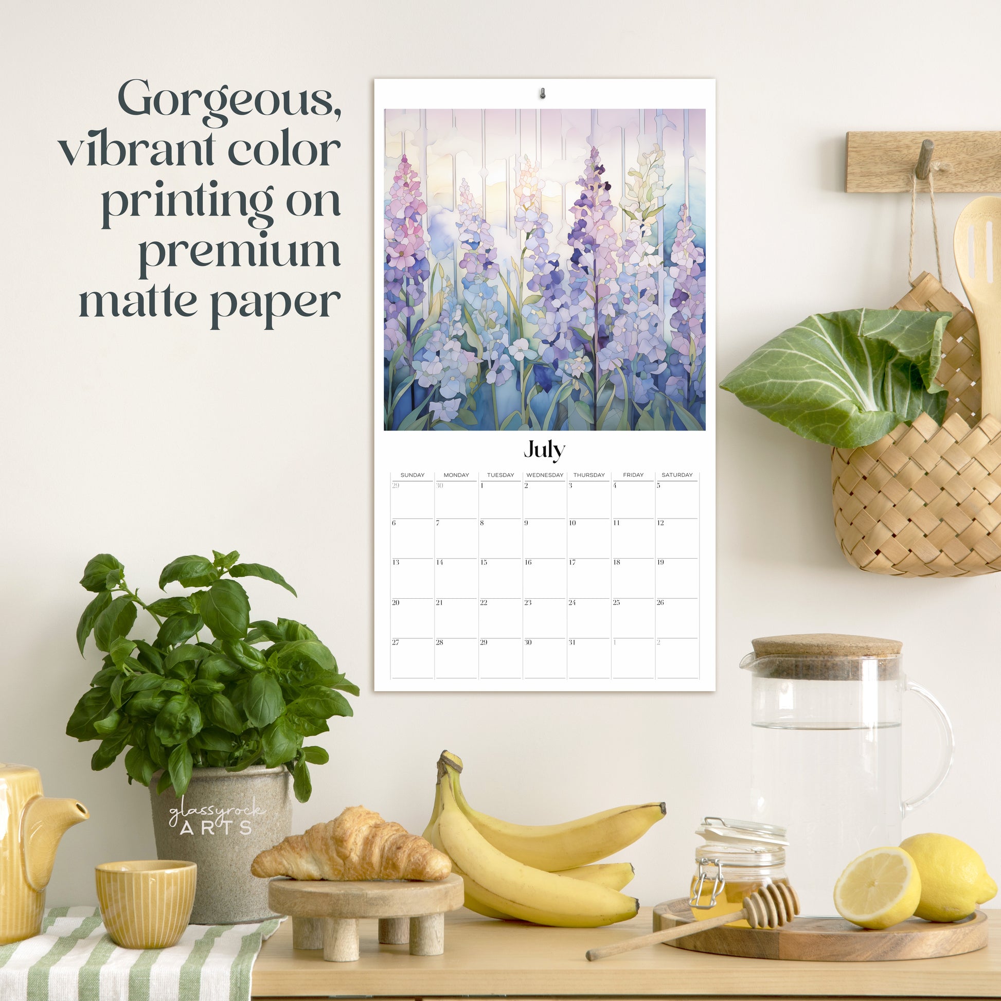 The birth flowers calendar hanging in a kitchen with kitchen tools below on a counter. It has gorgeous, vibrant color printing on premium paper.