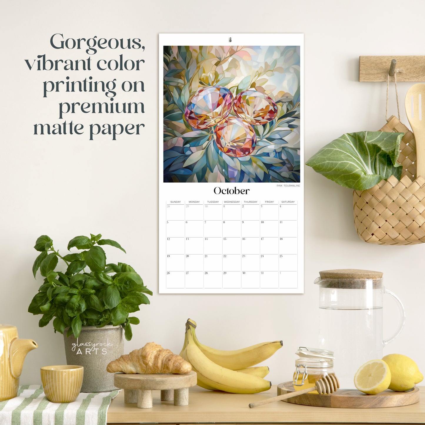 The birthstones calendar hanging in a kitchen with kitchen tools below on a counter. It has gorgeous, vibrant color printing on premium paper.