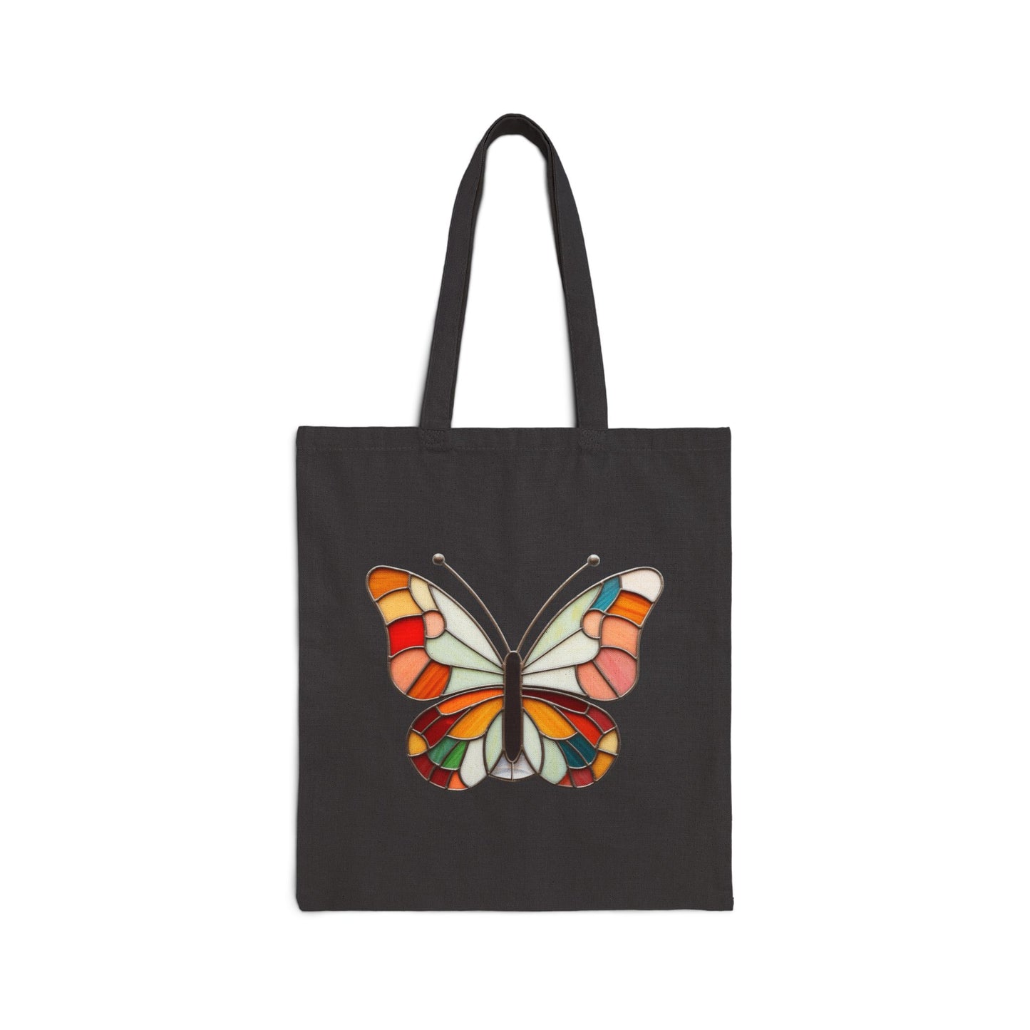 The Stained Glass Groovy Butterfly Cotton Canvas Tote Bag showcases a colorful butterfly with stained-glass effect wings in orange, red, blue, and white on a dark background, highlighting the original artwork.