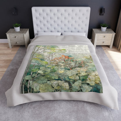 A bed with a white, tufted headboard is adorned with a Stained Glass Tropical Forest Crushed Velvet and Soft Fleece Blanket in green, orange, and gray. Two wooden nightstands with small plants are placed beside the bed on a gray rug.