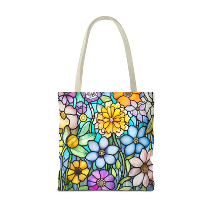 The Stained Glass Folk Art Flowers Tote Bag, crafted from durable polyester, features a vibrant floral design with blue, yellow, purple, and pink flowers on green. It includes light beige handles and is artist-designed. Available in 3 sizes.