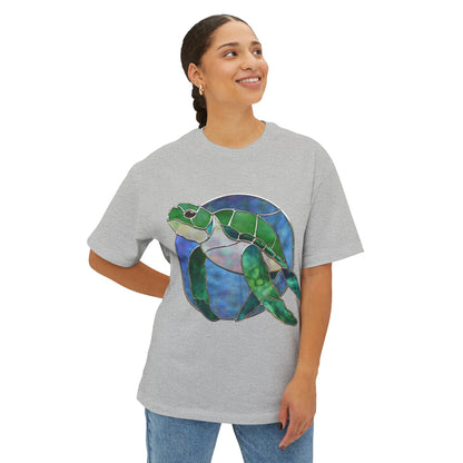 A person wearing a Bella+Canvas Stained Glass Turtle Oversized Tee Shirt in gray, smiling and looking to the side.