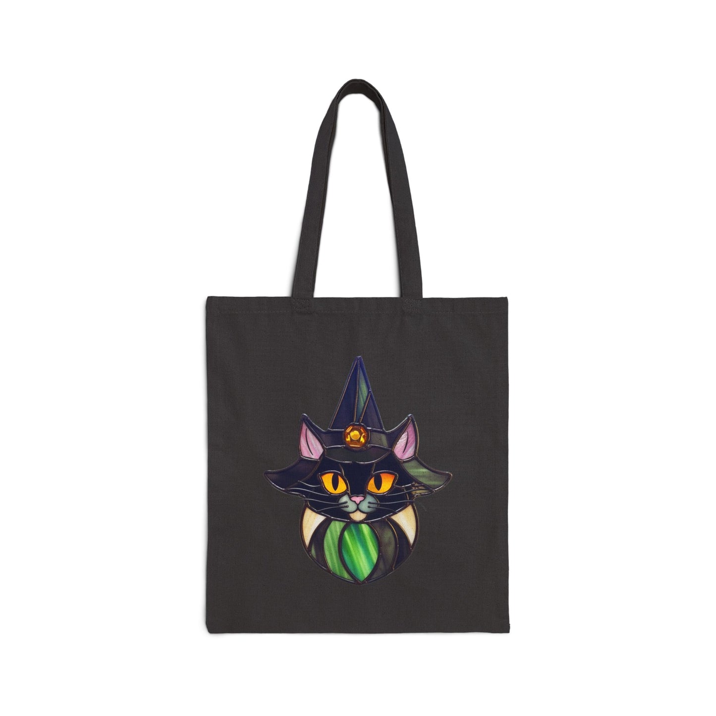 The Stained Glass Cat Witch Cotton Canvas Tote Bag, designed by Noelle Barnes, showcases a black cat with large orange eyes and a green scarf, wearing a gem-studded wizard hat adorned with stars. The plain background enhances the enchanting illustration.