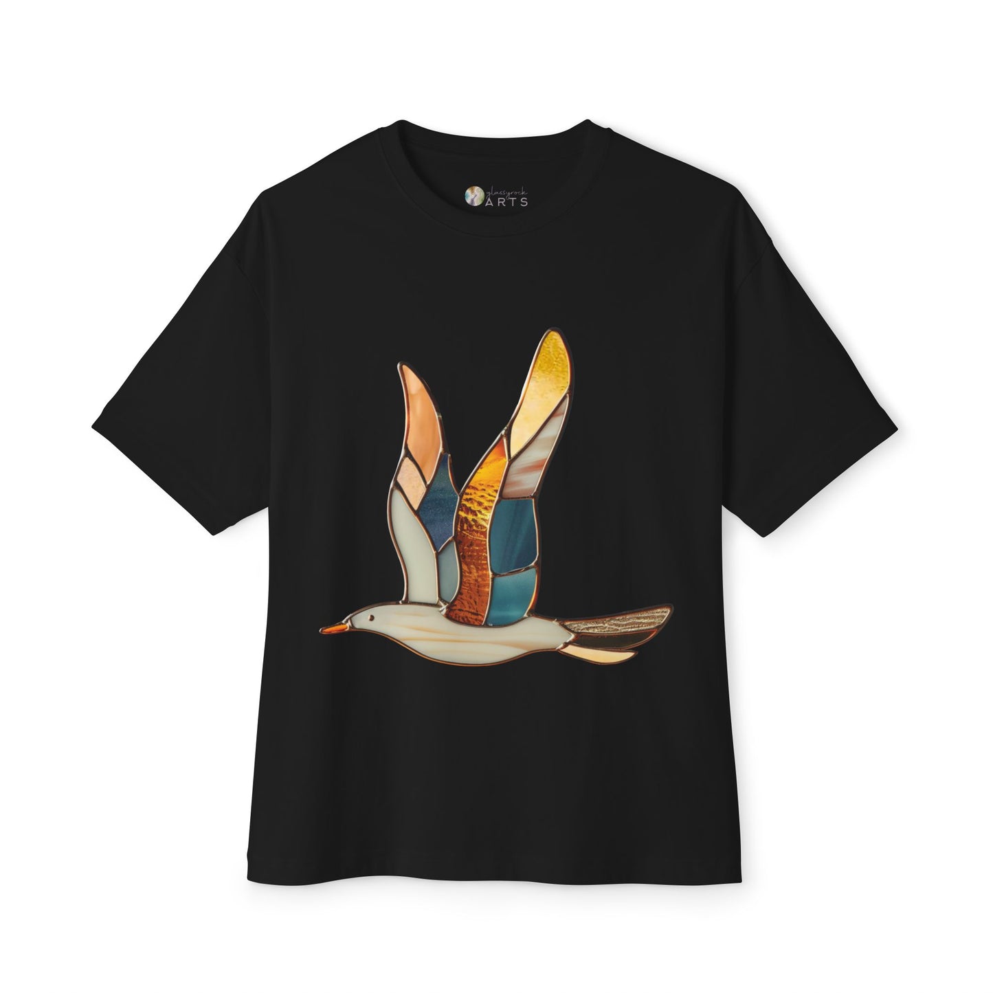 The Stained Glass Seagull Oversized Tee Shirt by Bella+Canvas showcases a stained glass-style design of a flying bird in shades of orange, yellow, blue, and brown. This eco-conscious t-shirt beautifully merges artistic flair with sustainable fashion.