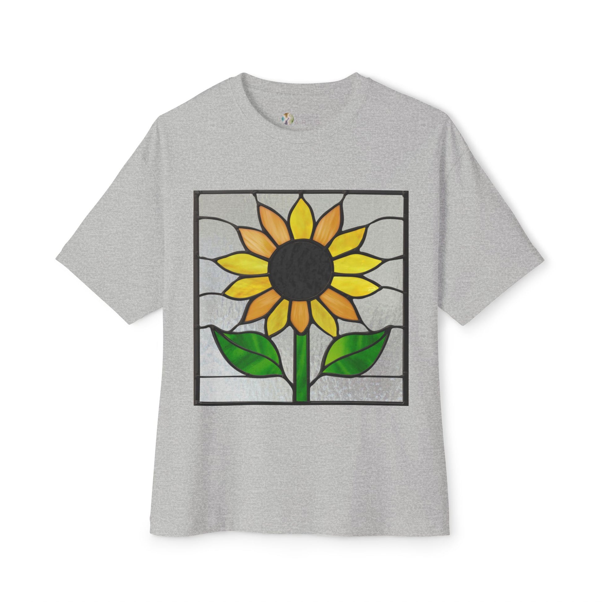 The Stained Glass Sunflower Oversized Tee Shirt from Bella+Canvas showcases an eye-catching artist-designed stained glass sunflower with vibrant yellow petals and lush green leaves on the front, seamlessly blending style with sustainable fashion.