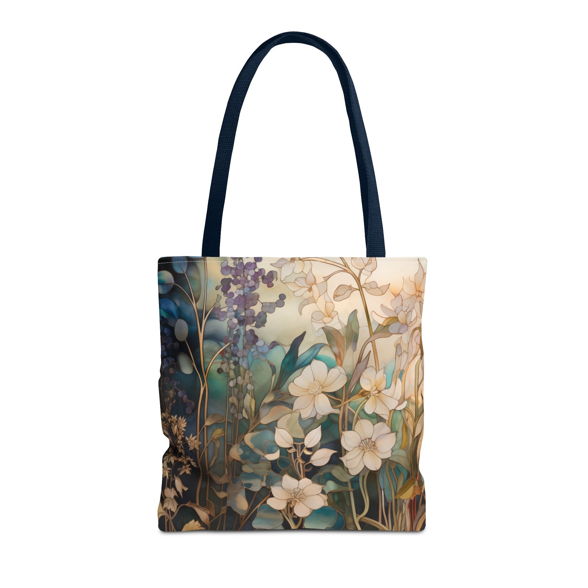 The Stained Glass Midnight Flowers Tote Bag, available in three sizes, is a durable polyester tote bag with dark handles. It features an artistic design of white flowers and greenery on a blue and beige background, reminiscent of stained glass.