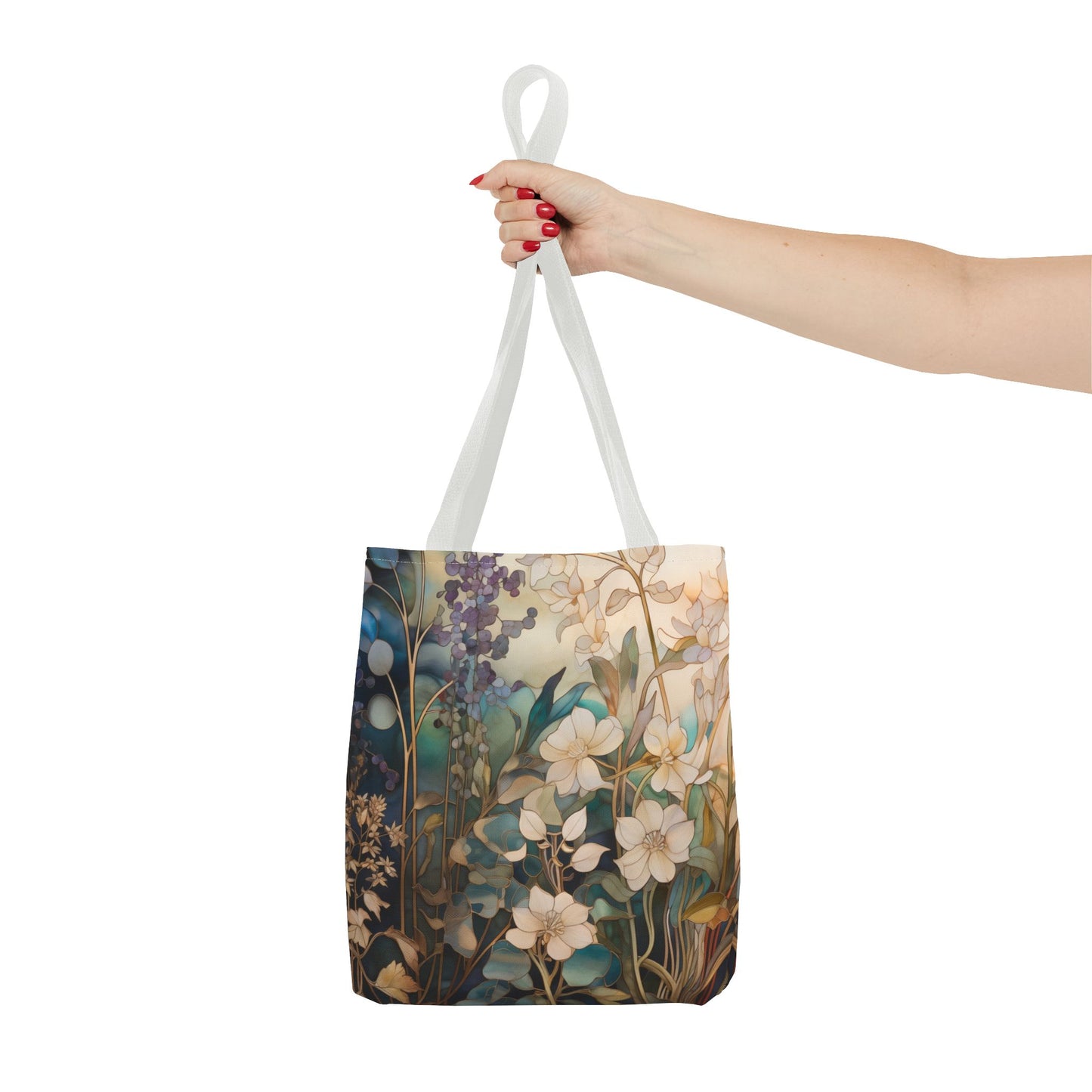 A hand holding the Stained Glass Midnight Flowers Tote Bag, showcasing a floral print design with various flowers and leaves against a white background. Crafted from durable polyester, this tote is both sturdy and charming. Available in 3 sizes.