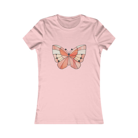 The Stained Glass Spring Butterfly Women's Tee Shirt is a light pink, comfortable T-shirt that features a stylized butterfly graphic in shades of peach and cream on the front, inspired by stained glass design.