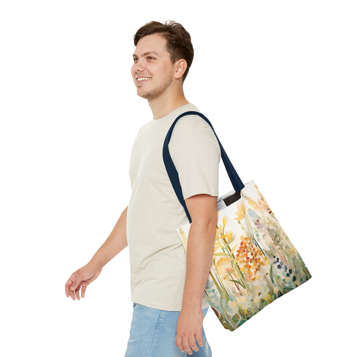 A person in a light gray T-shirt and blue jeans smiles while carrying the Stained Glass Fall Flowers Tote Bag with a colorful floral pattern. Crafted from durable polyester, they walk against a plain white background.