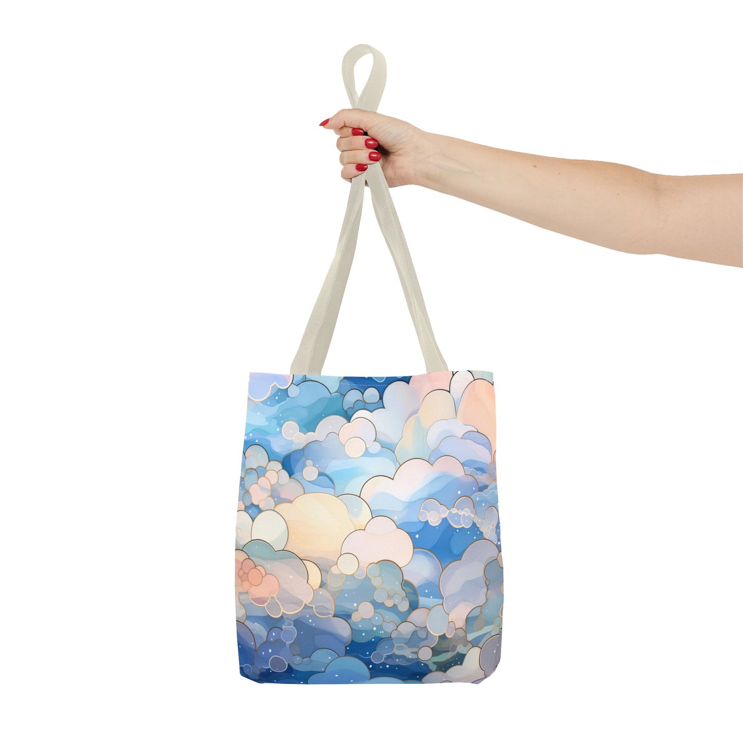 A hand with red nails holds the Stained Glass Clouds Tote Bag made of durable polyester, showcasing a colorful abstract cloud pattern in blue, white, and peach. The background is plain white.