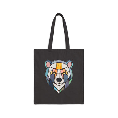 The Stained Glass Patchwork Bear Cotton Canvas Tote Bag is a black heavyweight tote showcasing Noelle Barnes original artwork. This design features a bears face with colorful geometric shapes in blue, green, orange, yellow, and brown.