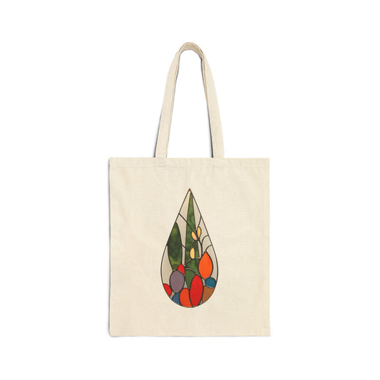 A beige cotton canvas tote bag with two handles, featuring a colorful abstract cactus teardrop design in the center inspired by stained glass artwork.