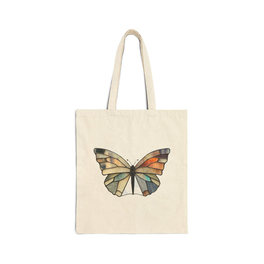 The Stained Glass Summer Butterfly Cotton Canvas Tote Bag showcases a butterfly illustration at the center, featuring an exquisite stained glass design.