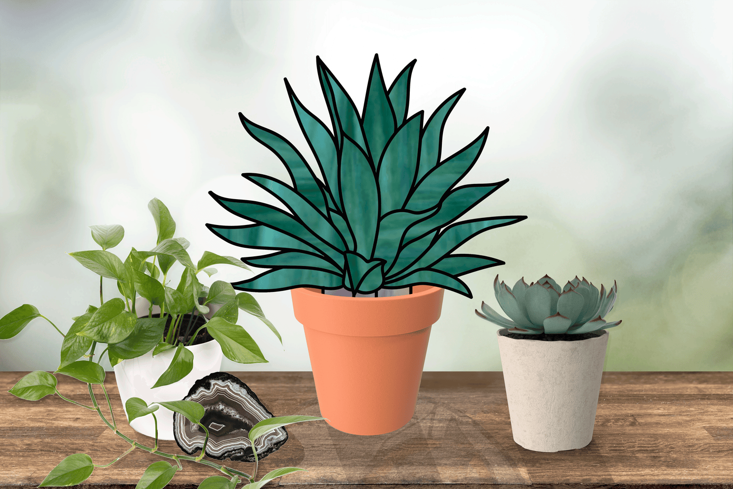 A stylized stained glass succulent from the Stained Glass Succulent Stems Pattern Pack of 4 sits in a terracotta pot on a wooden surface between two real plants. An agate slice enhances the scene against a blurred background, highlighting its artistic digital patterns.