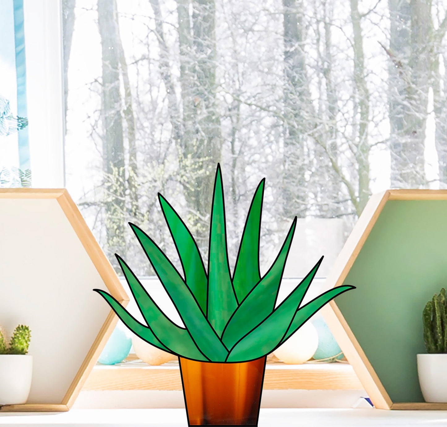 The Beginner Aloe Potted Plant Stained Glass Pattern displays a centered green aloe in a brown pot, set against an indoor scene with wooden shelves of small plants and a window revealing bare trees, ideal for beginners.