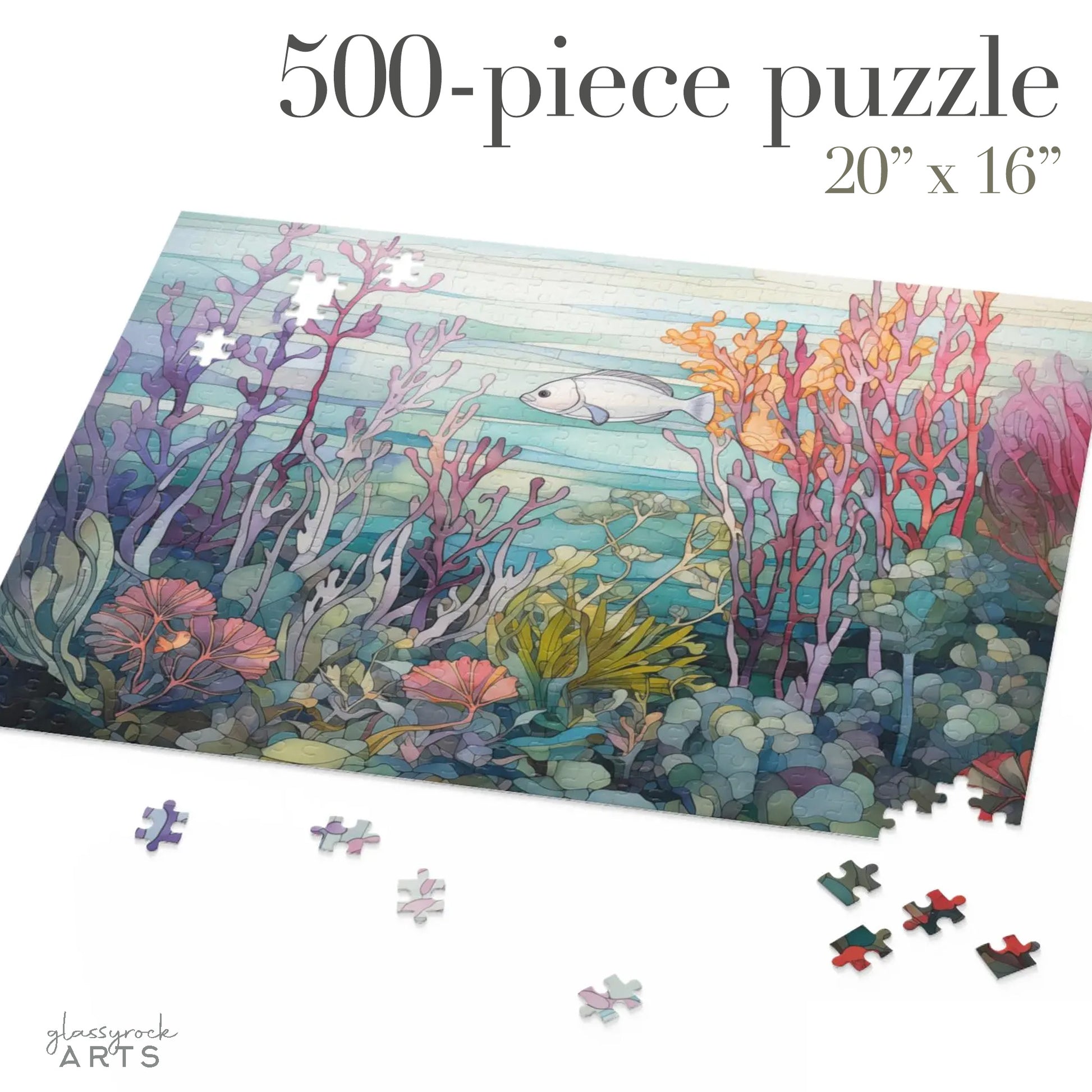 An image of a jigsaw puzzle featuring a stained glass illustration of a silver fish swimming amongst a purple, orange and pink coral reef. 500 pieces.