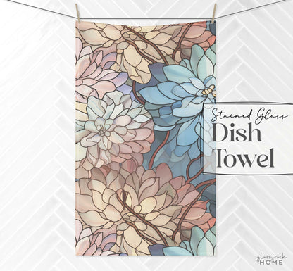 A hanging dish towel featuring a stained glass floral pattern in shades of blue, pink, and beige. The text reads "Stained Glass Dark Flowers Dish Towel." It's perfect for enhancing your kitchen aesthetics or as a delightful stained glass gift.