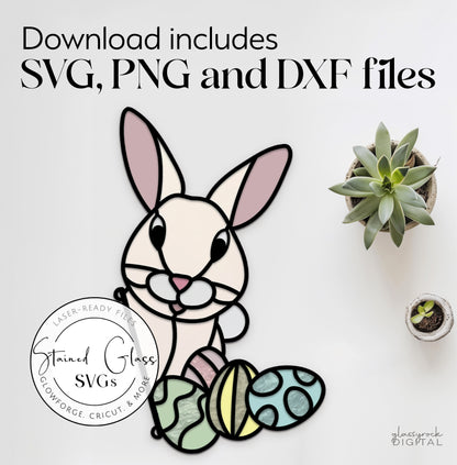 A flat illustration of a bunny with decorated eggs in a stained glass style is shown, next to a small succulent and coffee cup. Text reads, Stained Glass Easter Bunny SVGs, available for download in PNG and DXF formats.