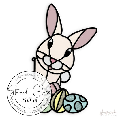 A stained glass-style bunny with pink ears holds a carrot, designed as an SVG file. Three Easter eggs lie at its feet. A label reads: Stained Glass Easter Bunny SVGs - Laser-Ready Files for Glowforge, Cricut & More.