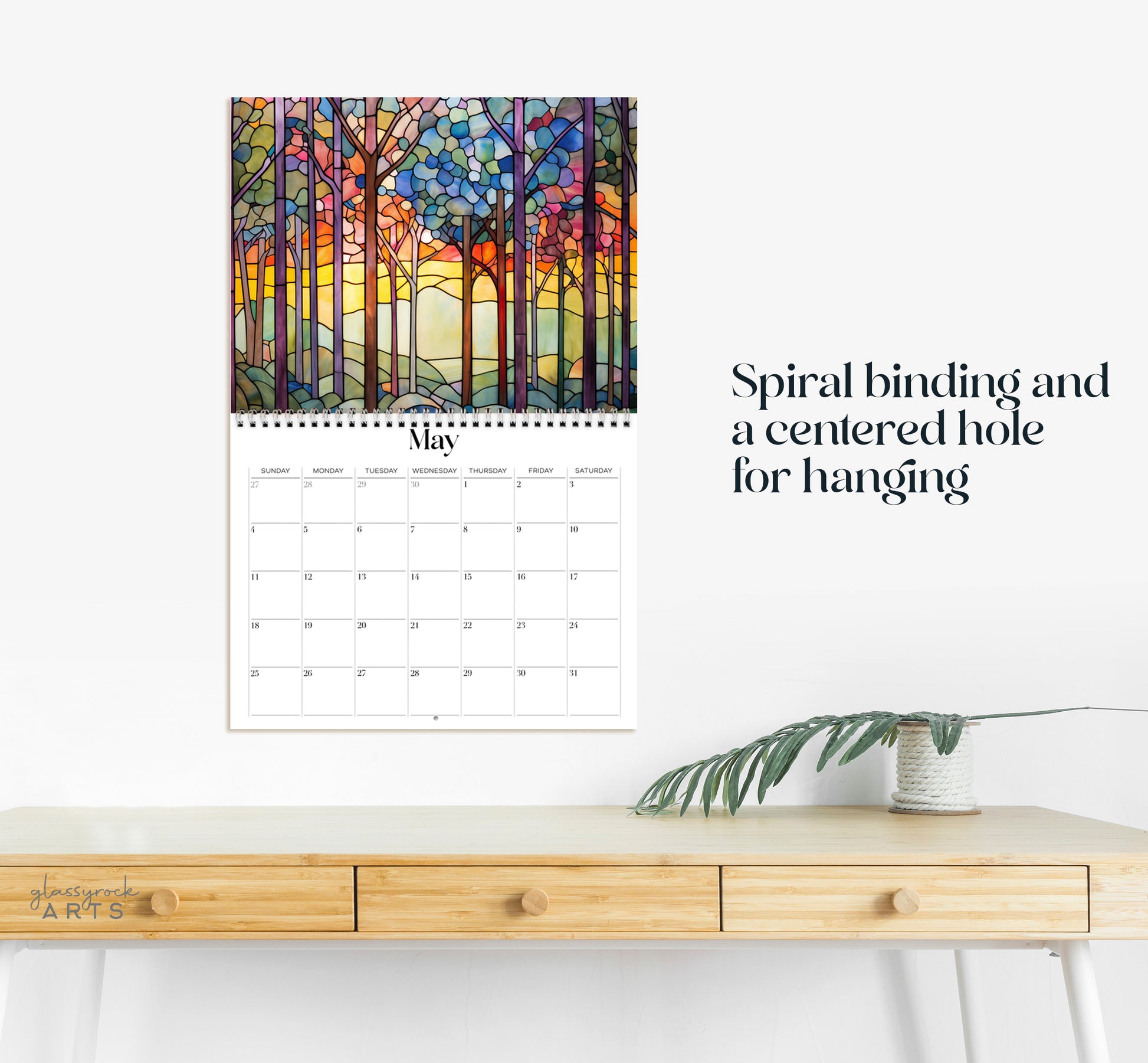 This calendar has a spiral binding and a centered hole for hanging.