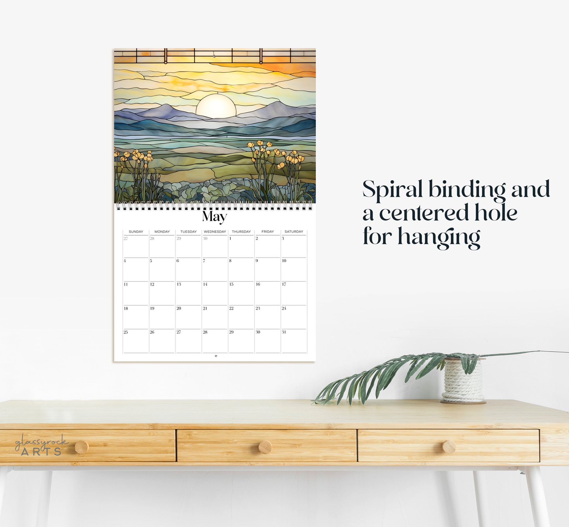 This calendar has a spiral binding and a centered hole for hanging.