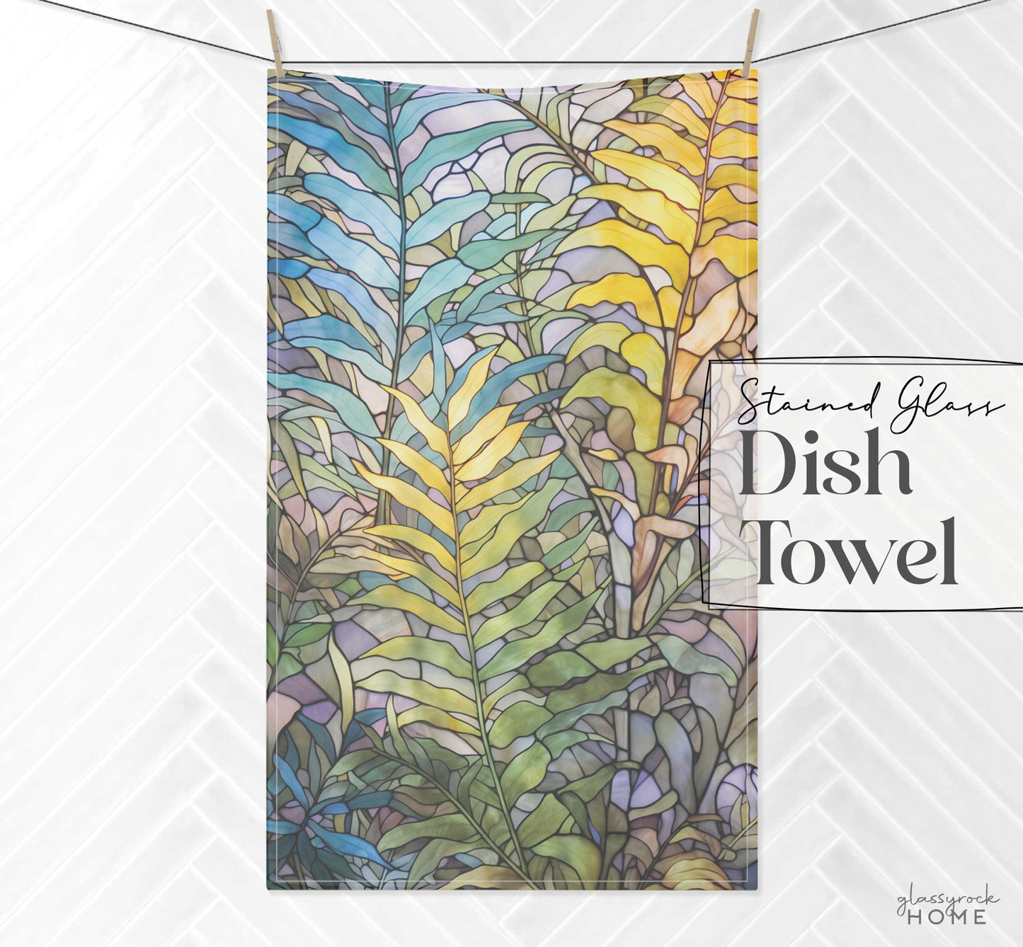 A dish towel adorned with a stained glass fern pattern in pastel colors hangs on a line against a white background. Crafted from natural cotton twill, the text "Stained Glass Pastel Ferns Dish Towel" is displayed in the image.