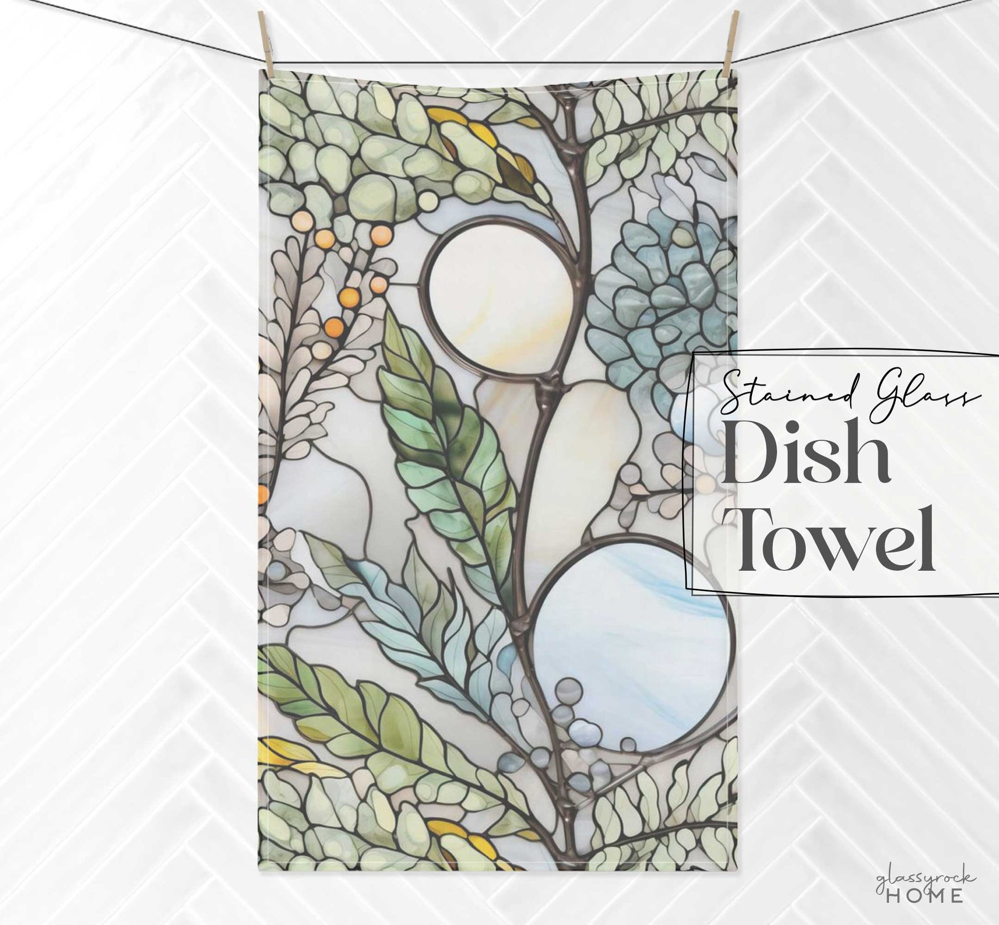 A custom creation, this kitchen towel showcases a stained glass design with ferns and berries, hanging on a line against a tiled wall. Text reads "Stained Glass Nouveau Ferns Dish Towel" and "Hearthrock Home" in the bottom right corner.