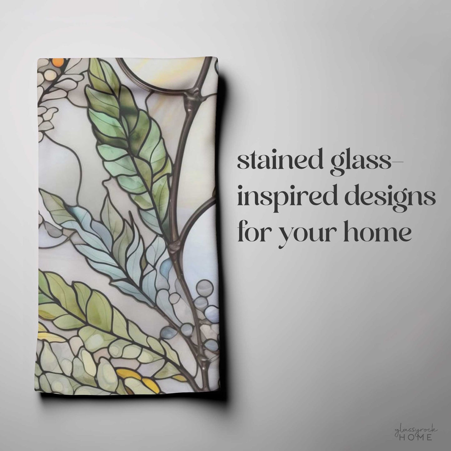 A folded fabric with a stained glass-inspired leaf and floral design on a gray background. Text: "Stained Glass Nouveau Ferns for your home" in large, decorative font. This stunning Stained Glass Nouveau Ferns Dish Towel is the perfect custom creation to add an artistic touch to your space.