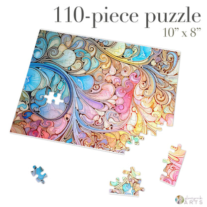 The Stained Glass Rainbow Paisley Jigsaw Puzzle is a vibrant 110-piece set with intricate swirling patterns in blue, pink, and yellow. At 10x8 inches, pieces scatter beside the partially completed puzzle. Its a perfect gift for any occasion.