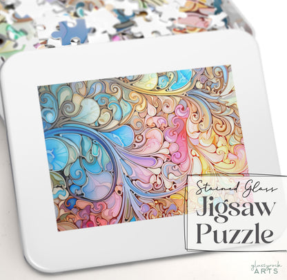 A close-up of the Stained Glass Rainbow Paisley Jigsaw Puzzle, featuring swirling stained glass patterns in blue, pink, and yellow. Partially assembled on a white surface, this perfect puzzle gift reads Stained Glass Rainbow Paisley Jigsaw Puzzle and glassrock ARTS in the corner.