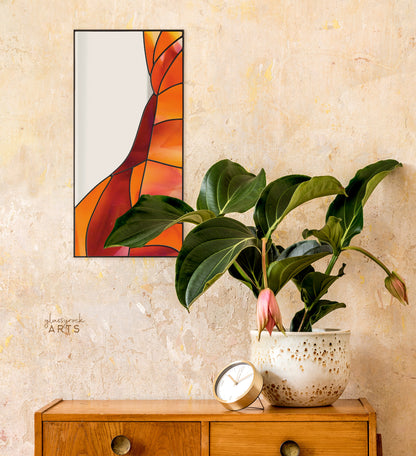 A rectangular mirror panel where the mirror glass occupies the upper left side while red and orange stained glass makes rock-like shapes along the rest of the piece. The panel is rectangular and tall. It hangs on a stucco wall above a dresser with a flowering plant.